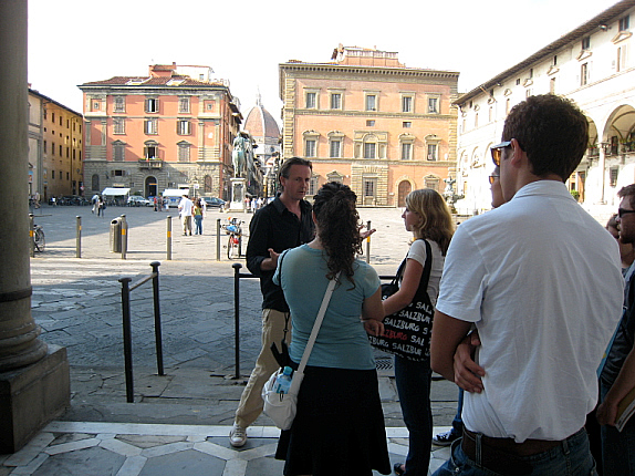 Mac Manus explaining the design of Piazza SS. Annunziata with the Duomo of Florence in the background.